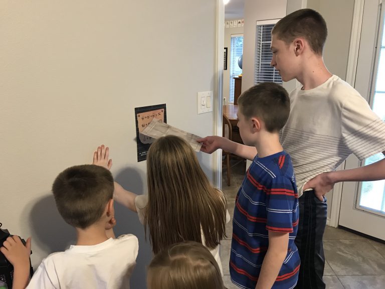 Kids around a table playing a murder mystery detective game