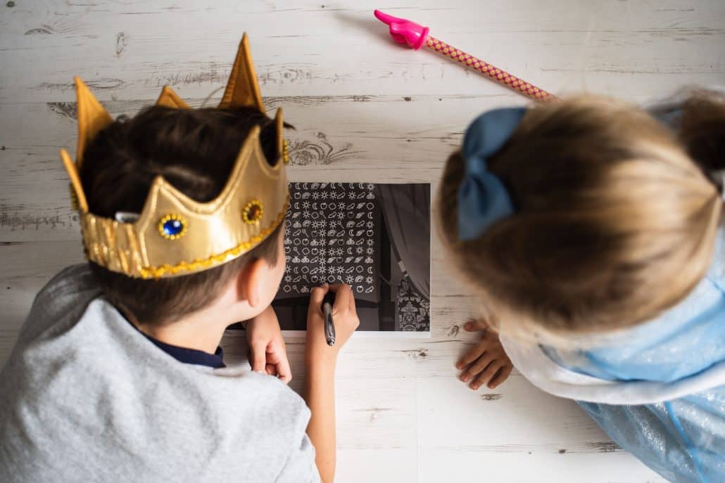 Zwei Kinder entschlüsseln eine Geheimschrift mit einer Symbol-Tabelle