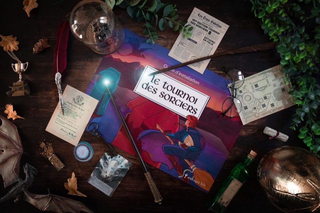 Kit Le tournoi des sorciers étalé sur une table avec baguette, bougies et parchemins