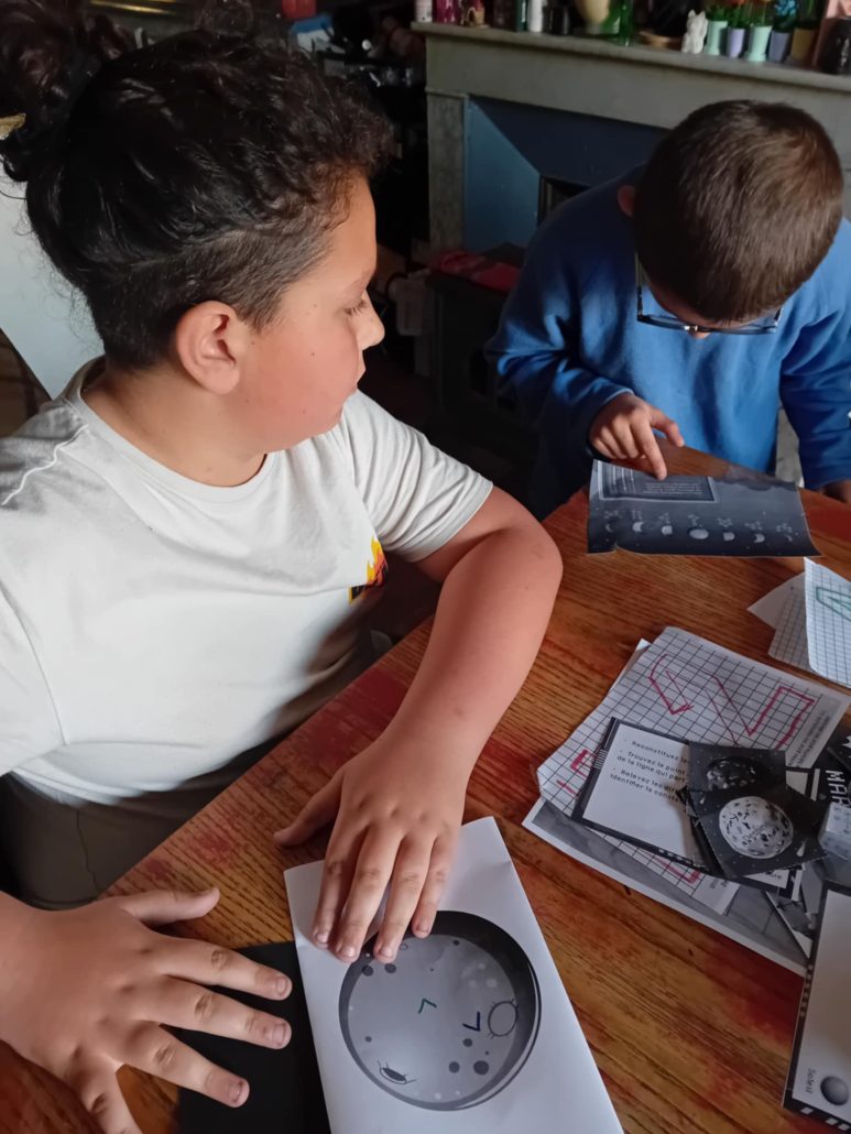 Kinder lösen ein Geheimschrift-Rätsel mit einer Codescheibe