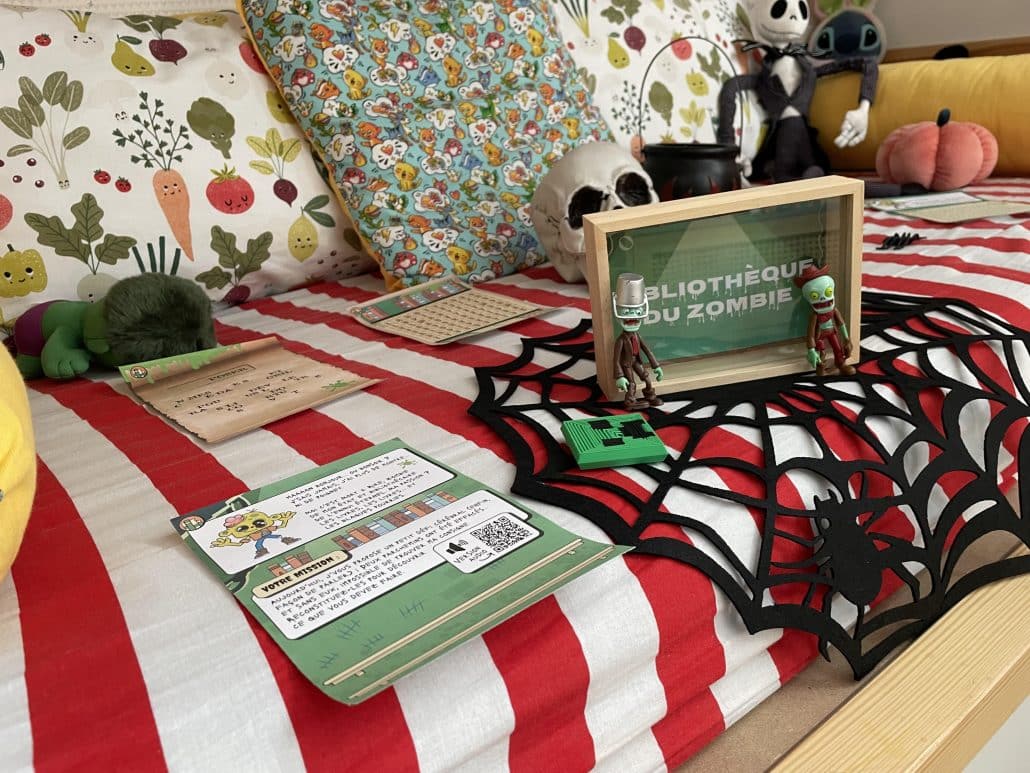 Installation d'un jeu d'Halloween sur un lit : toile d'araignée, crâne et carte de mission imprimée