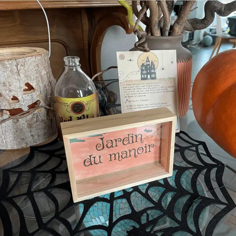 Panneau Jardin du manoir posé sur une table décorée pour Halloween