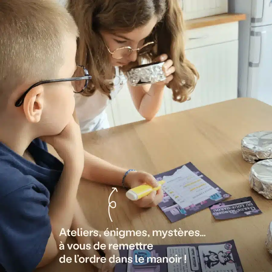 Deux enfants penchés sur des documents de jeu Halloween autour de la table de la cuisine