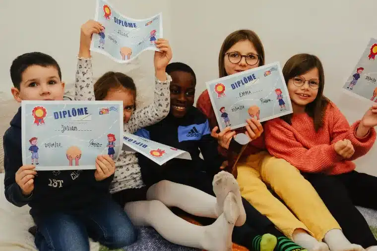 Cinq enfants brandissent fièrement leur diplôme à la fin de la partie
