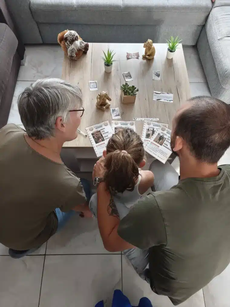 Deux adultes et un enfant penchés ensemble sur les documents de l'enquête