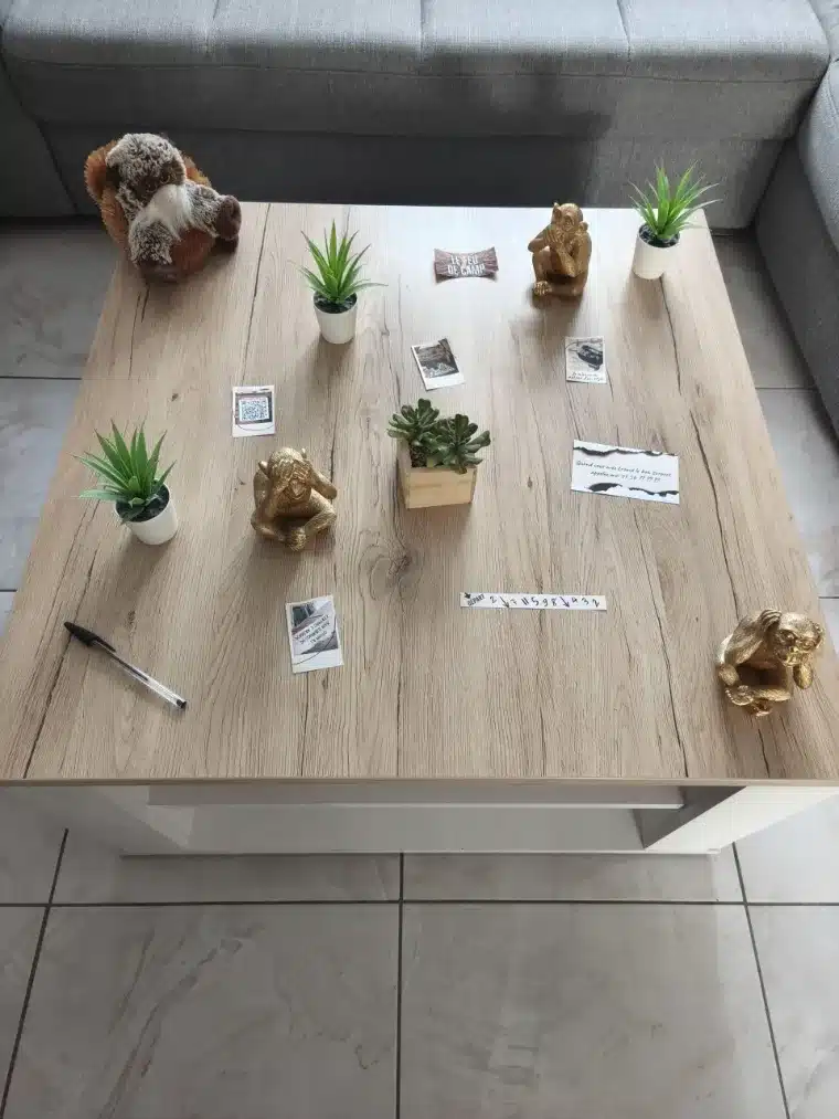 Table basse de salon installée pour un escape game maison, documents et objets disposés