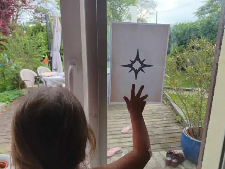 Un enfant lève la main devant une carte à symbole